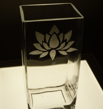 A glass vase etched with a lotus flower design on the Vitreus Art etching class