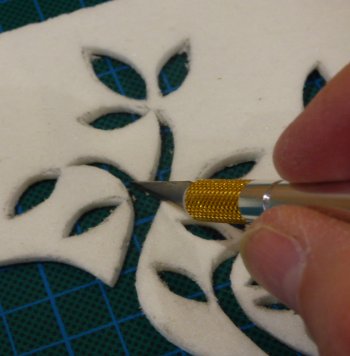 cutting the fibre paper to create relief in your fused work
